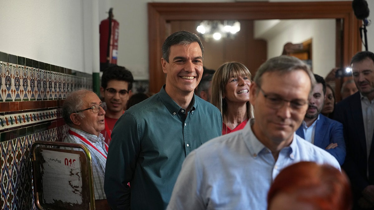 Spains Prime Minister Pedro Sanchez smiles for cameras upon arriving to the polling station