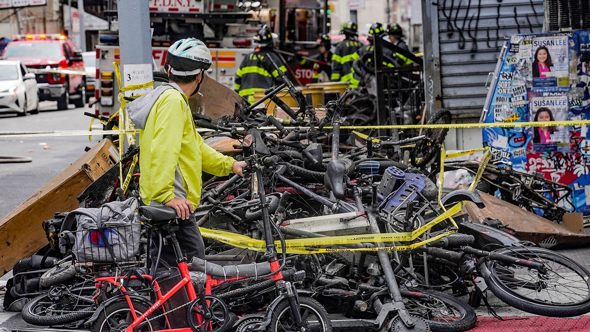 A biker stops to look at a pile of e-bikes 