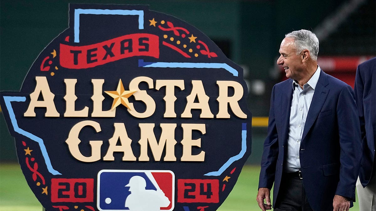 Rob Manfred smiles next to 2024 All-Star Game logo