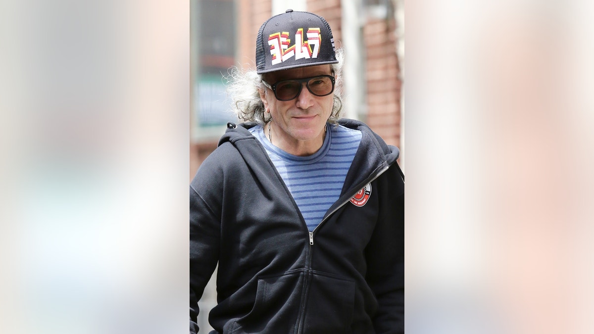 Daniel Day-Lewis wears a hat and sunglasses while walking down the street.