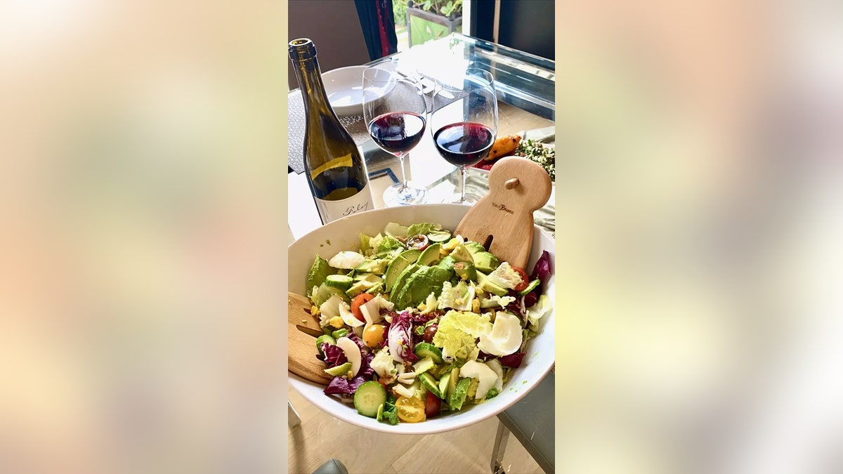 Brooke Burkes junk salad next to a glass and bottle of wine