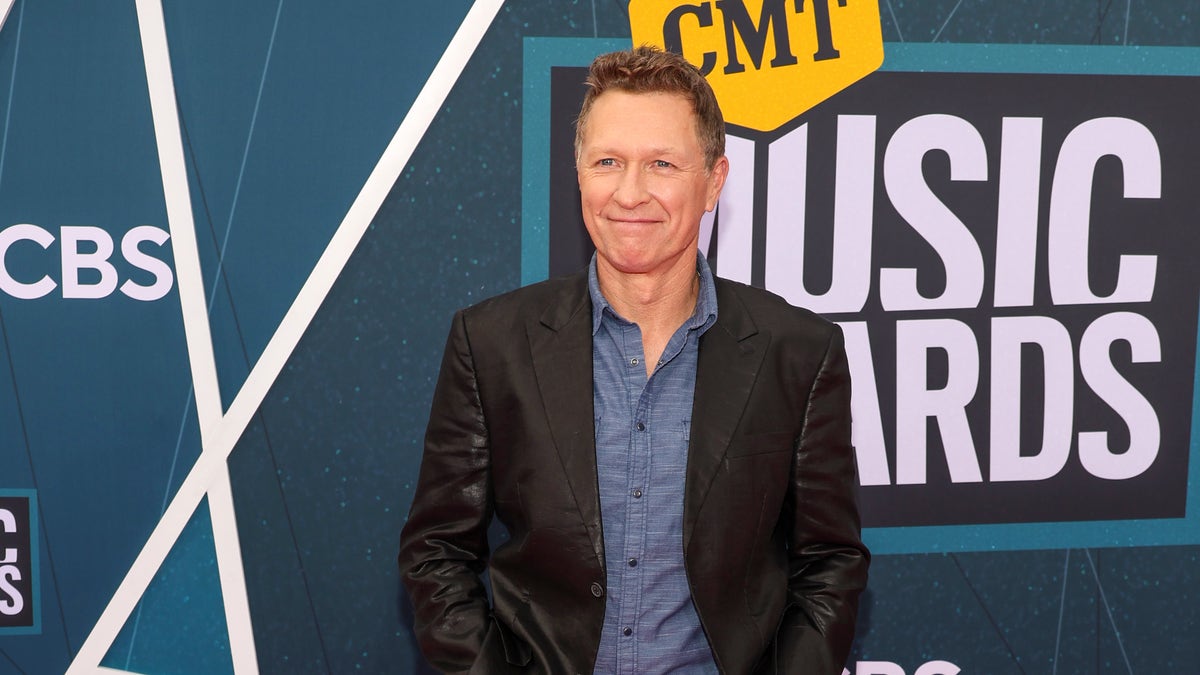 Craig Morgan wearing a suit jacket in from of CMT Music Awards signage