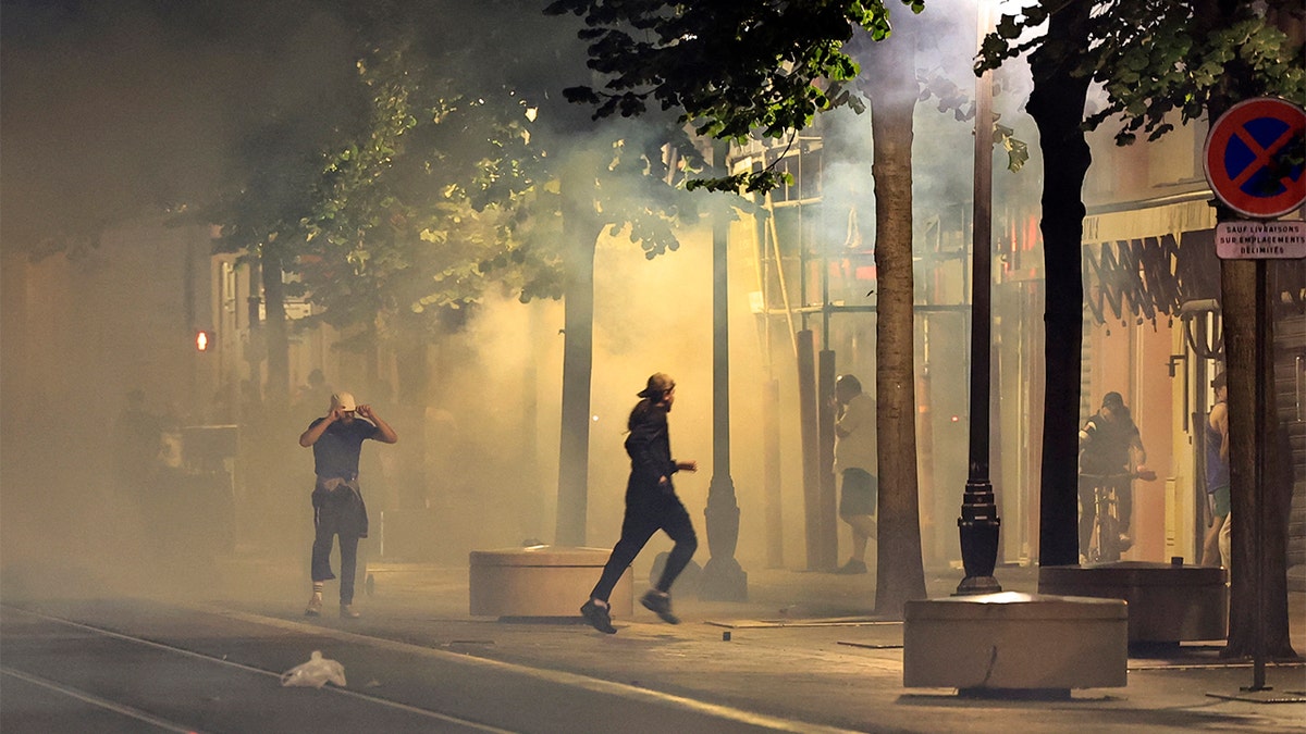 Protestors running away from smoke.