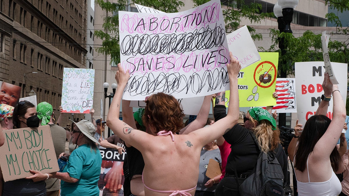 Ohio pro-abortion protester holds a sign that claims abortion saves lives