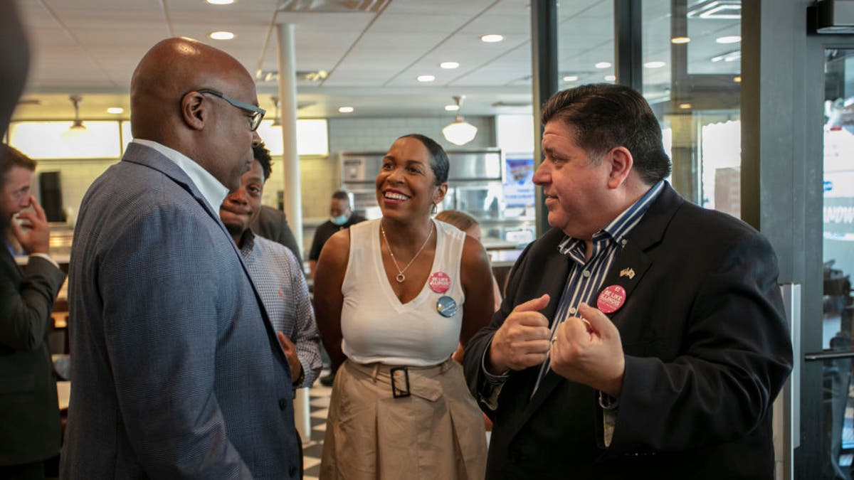  Illinois Governor J.B. Pritzker (R) and Illinois Lieutenant Governor Juliana Stratton (C) speak to Illinois Attorney General Kwame Raoul (L) on Primary Day at Manny's Deli on June 28, 2022 in Chicago, Illinois. 