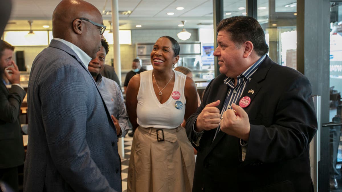  Illinois Governor J.B. Pritzker (R) and Illinois Lieutenant Governor Juliana Stratton (C) speak to Illinois Attorney General Kwame Raoul (L) on Primary Day at Manny's Deli on June 28, 2022 in Chicago, Illinois. 