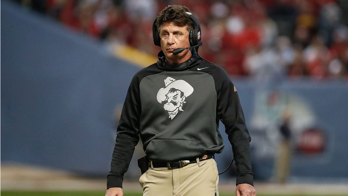 Mike Gundy loos on during a bowl game