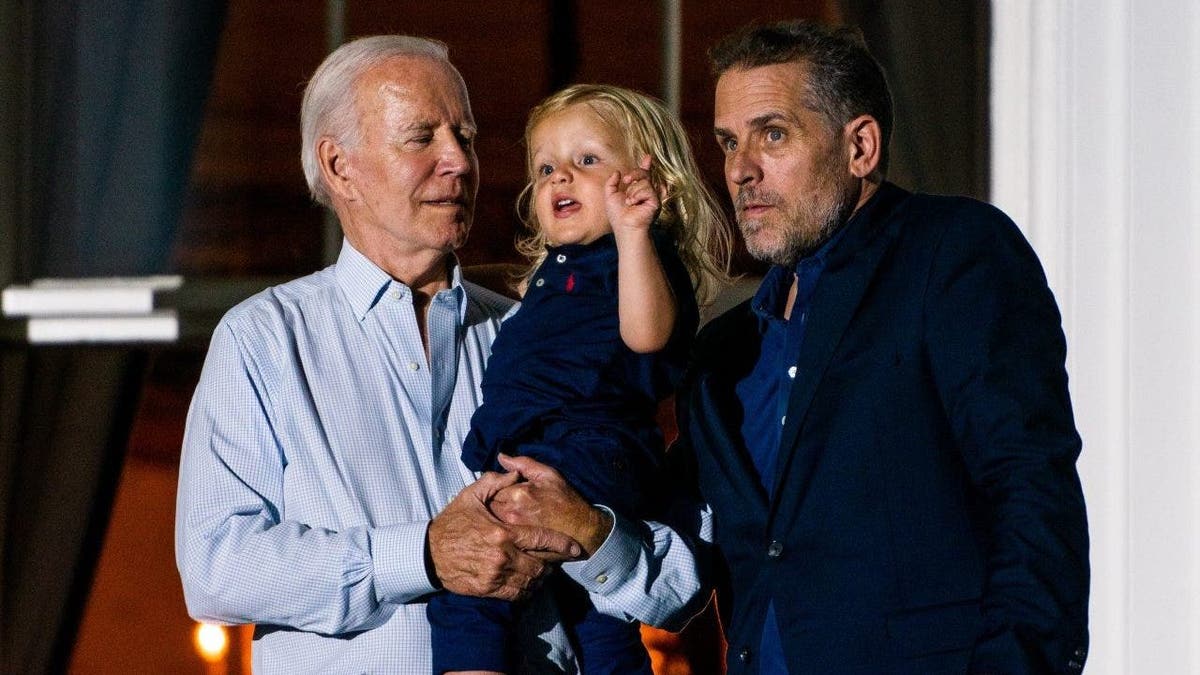 President Joe Biden holds his grandson Beau Biden with his son Hunter Biden