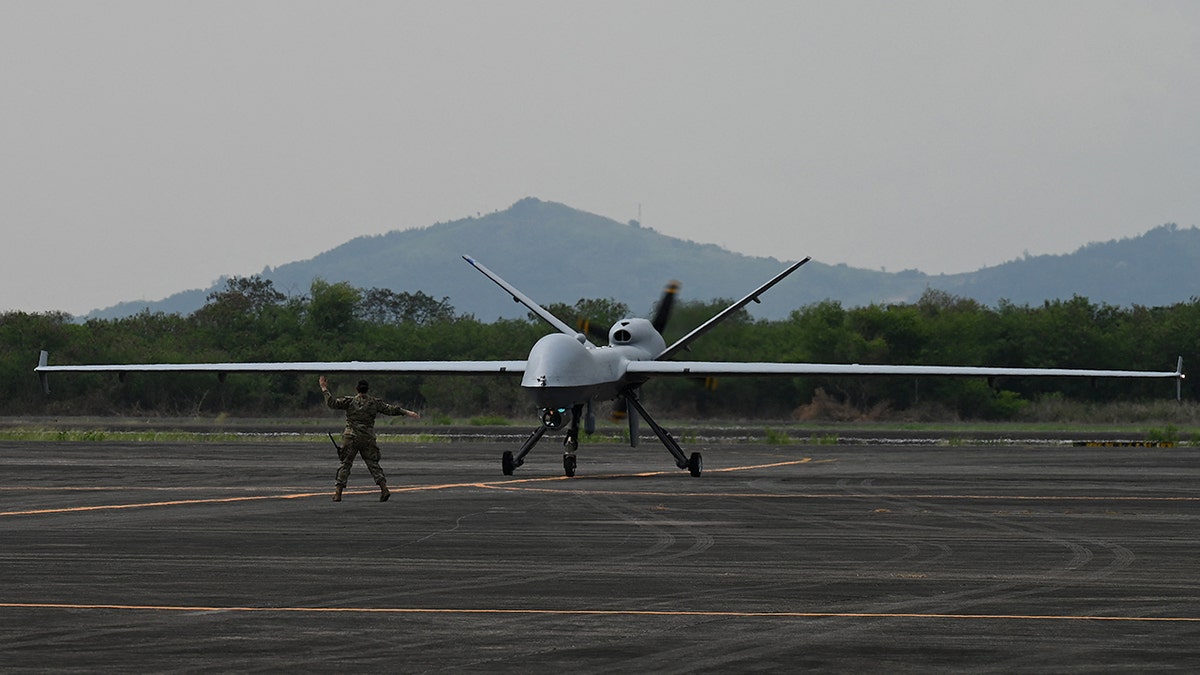 A US soldier guides the MQ-9 Reaper drone