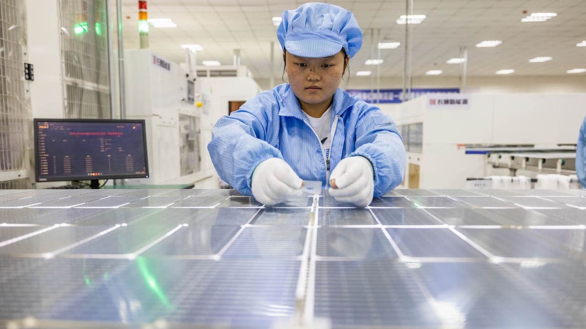 Unos trabajadores construyen un panel solar en un parque industrial energético de Bijie, China, el 11 de junio de 2023. China tiene una cuota superior al 80% en todas las fases de fabricación de paneles solares.