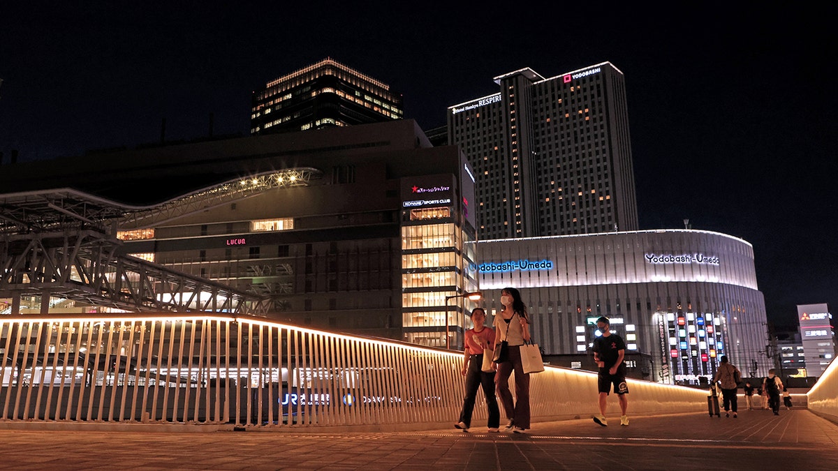 Pedestrians walk on a footbridge in Osaka, Japan.
