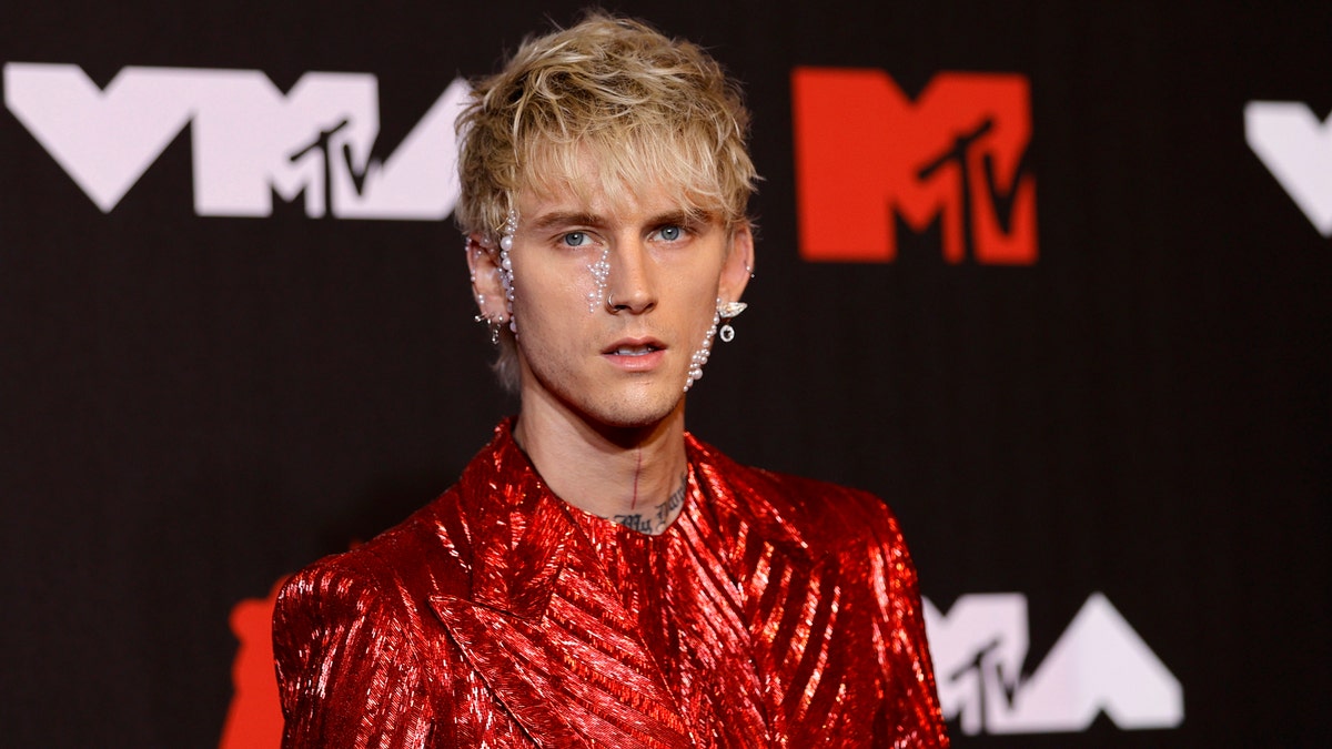 Machine Gun Kelly in a metallic red outfit in New York