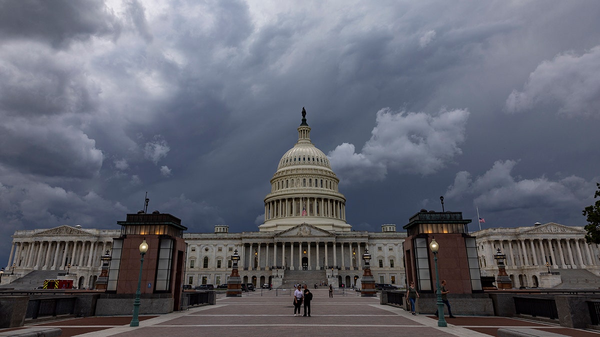 US Capitol against ominous storm cloud sky