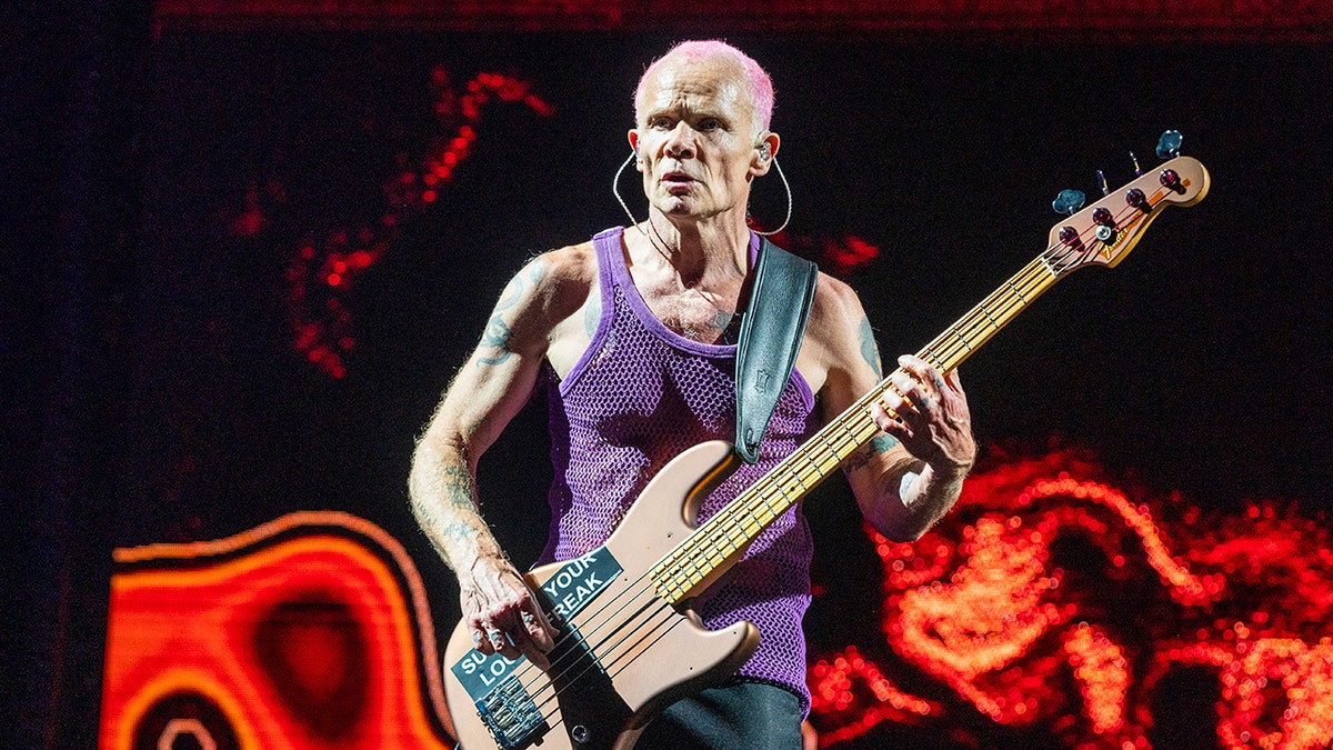 Flea performing onstage in with bass