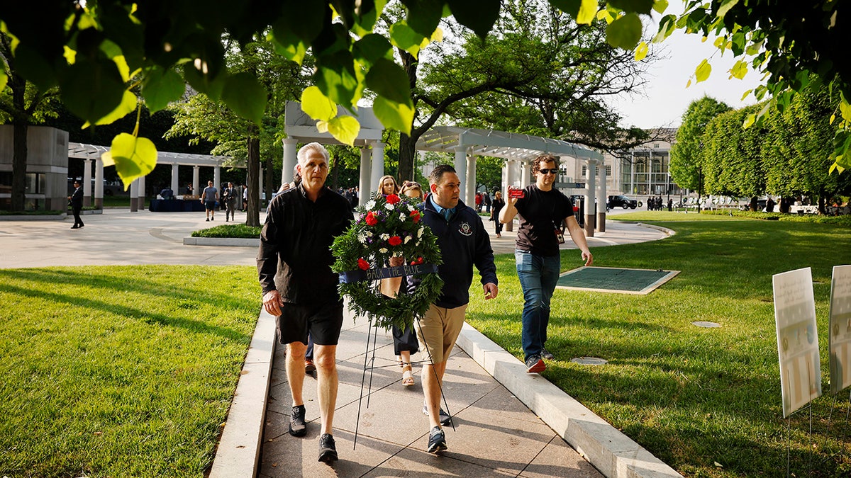 D'Esposito seen carrying a police officer memorial wreath with Kevin McCarthy