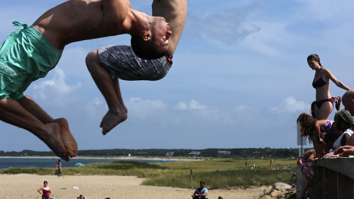 People jump off 'Jaws Bridge' during JawsFest