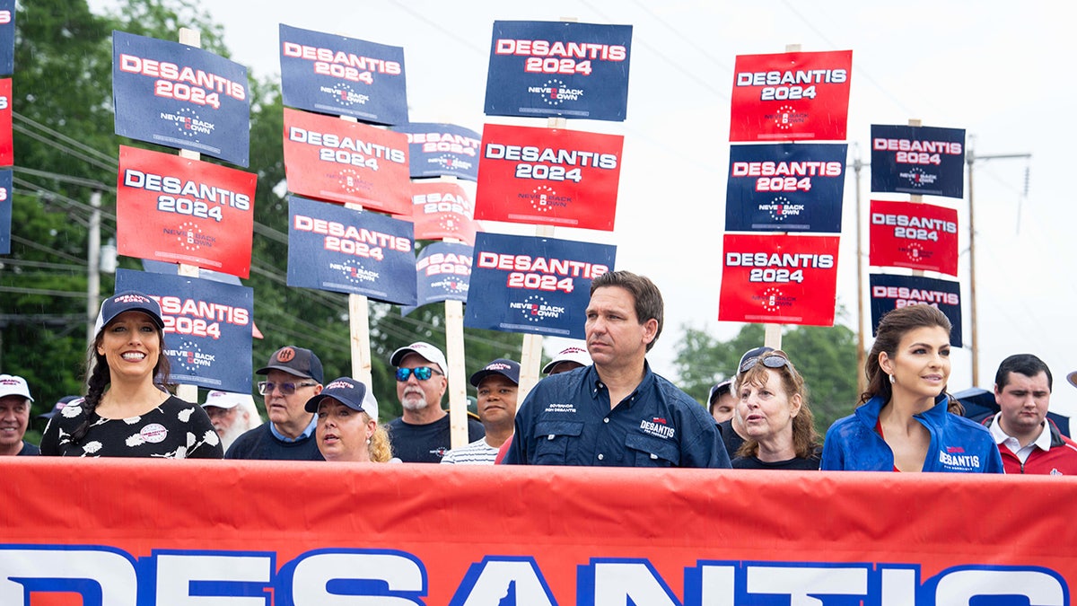 DeSantis, his wife and supporters with campaign signs