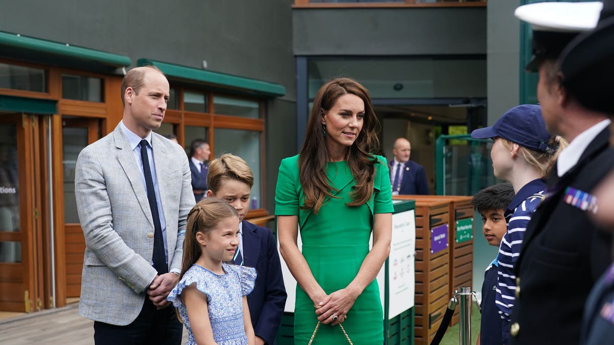 Prince William, Princess Charlotte, Prince George, and Kate Middleton talking with tennis officials