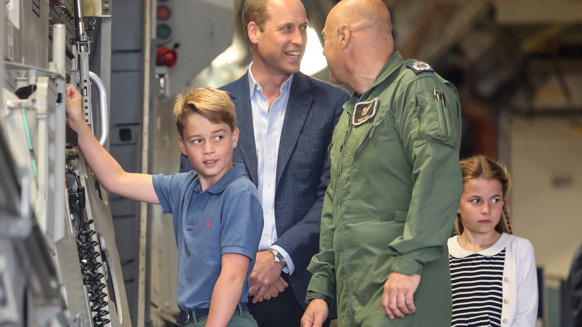 A photo of Prince William and Prince George looking at aircraft controls