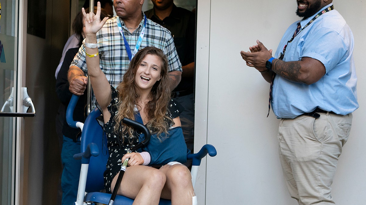 Julia Fatum makes a rocker sign in a wheelchair