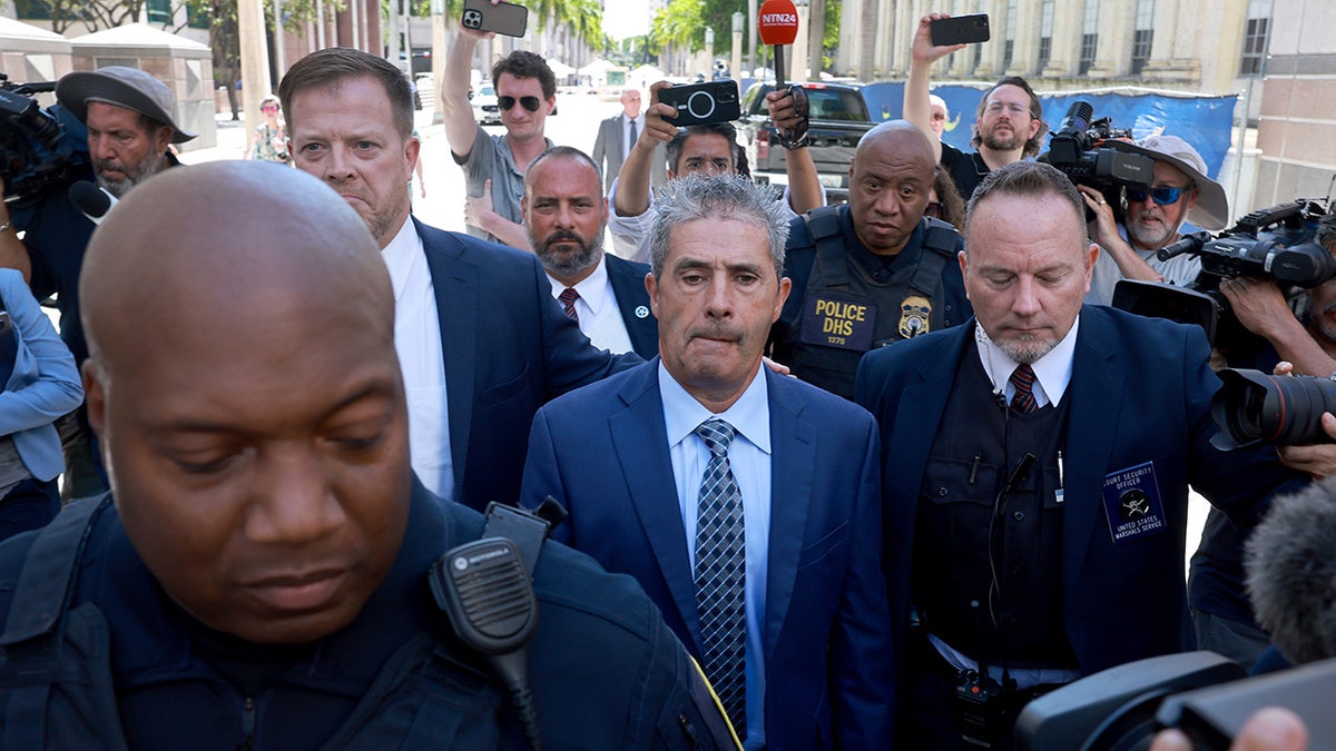Carlos De Oliveira outside Miami courthouse surrounded by press