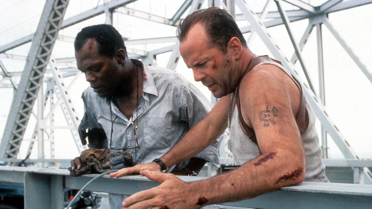 Samuel L Jackson and Bruce Willis standing on a bridge, looking down in a scene from the film Die Hard: With a Vengeance