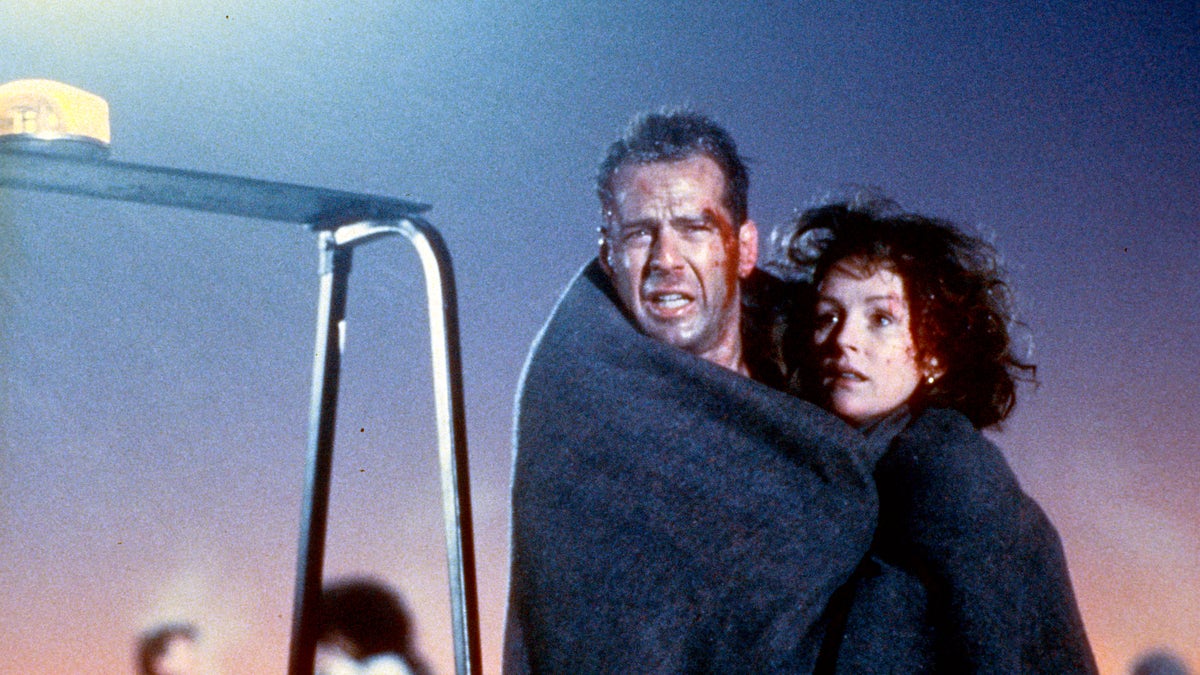 bruce willis and bonnie bedelia wrapped in a blanket at the end of die hard 2