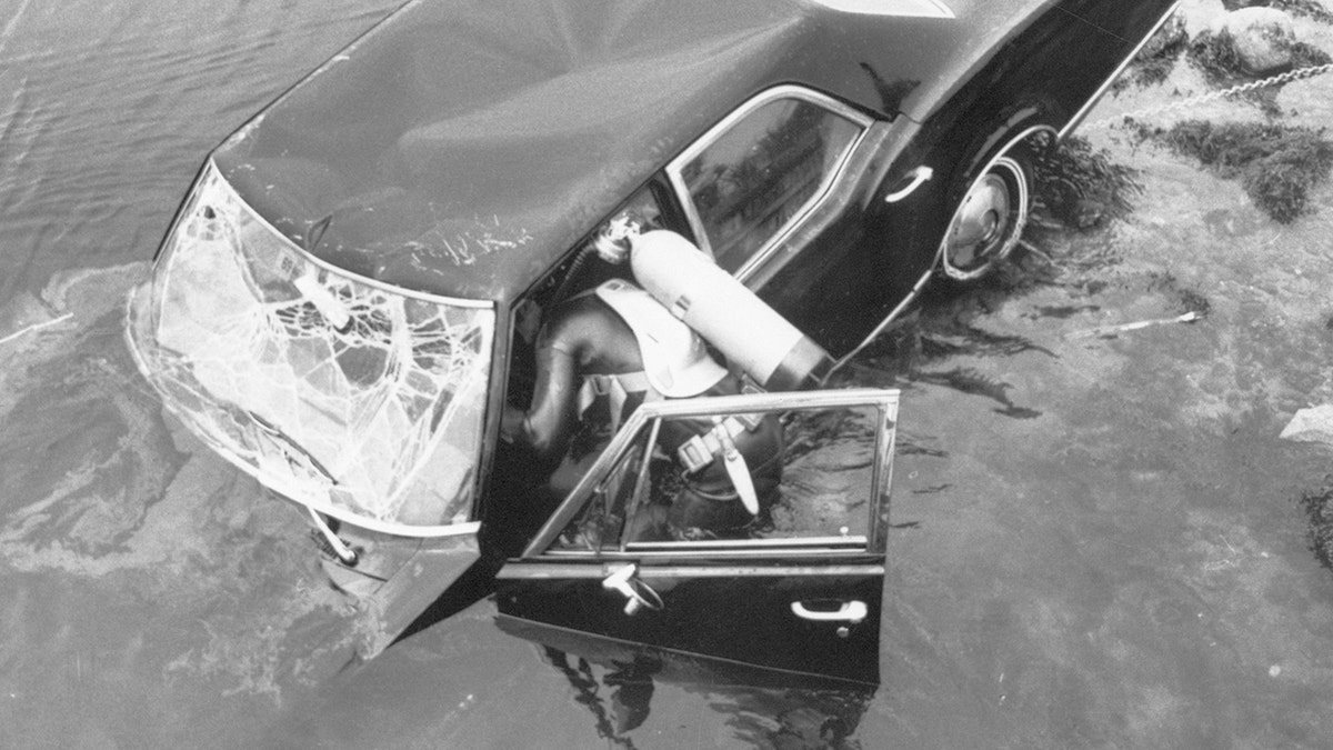 crashed car being inspected by a diver