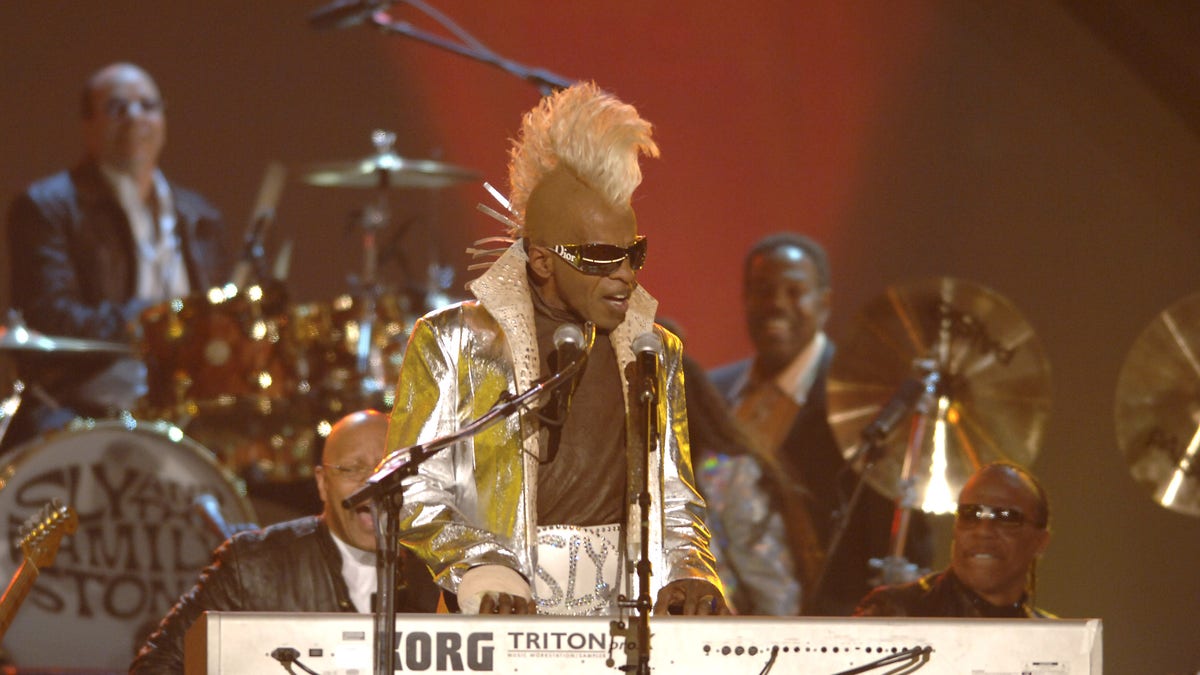 Sly Stone performs onstage with yellow mohawk