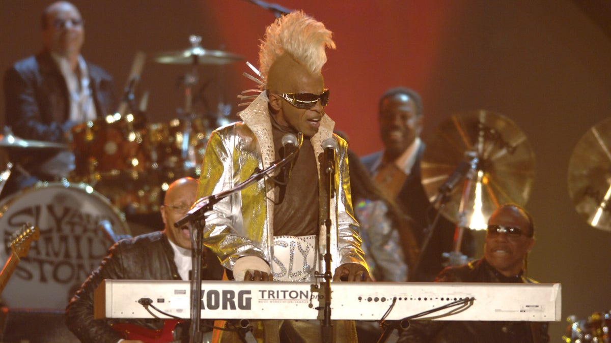 Sly Stone performs onstage with yellow mohawk