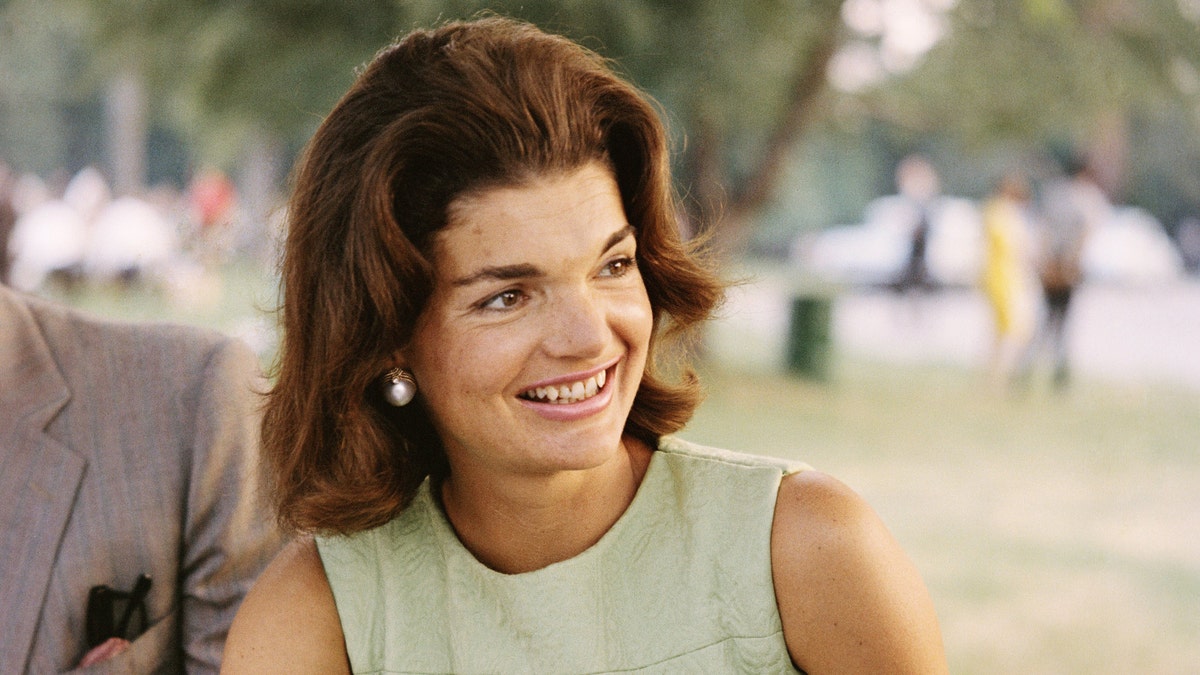 Jackie Kennedy looks to her left in a light green outfita