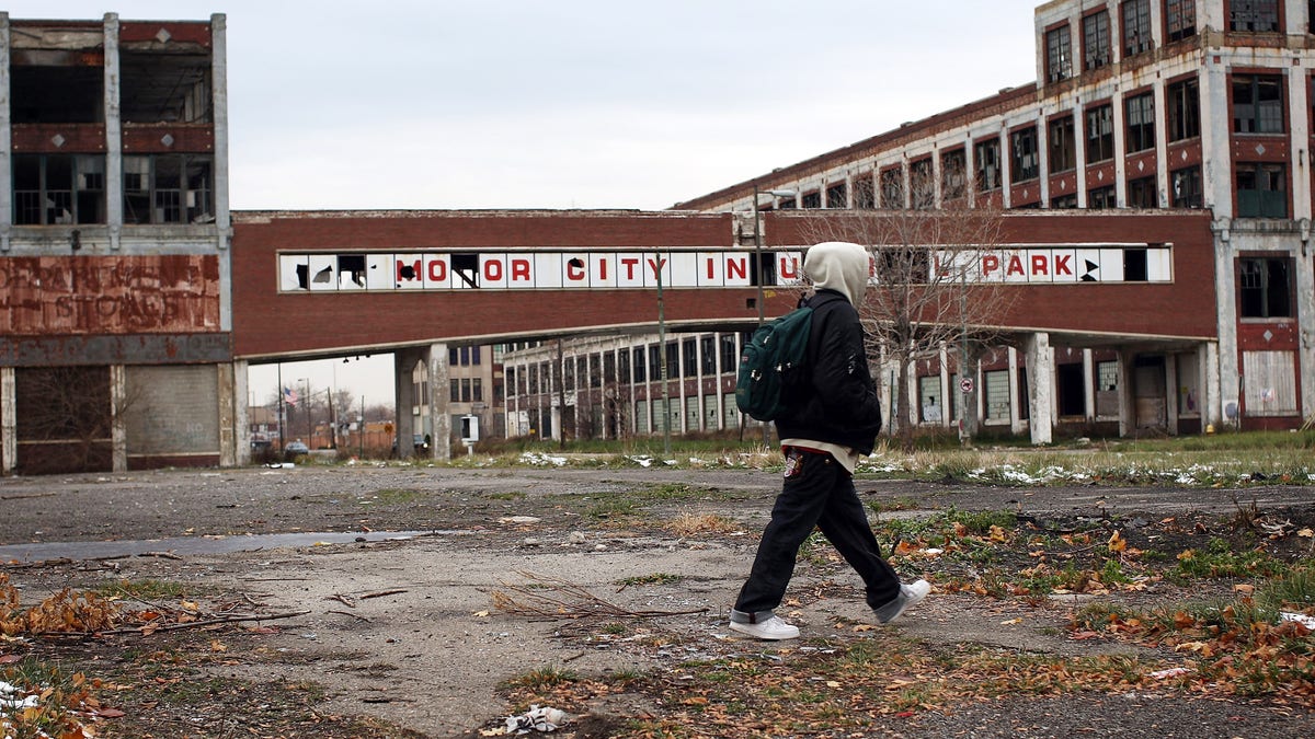 A person walks past the remains of the Packard Motor Car Company, which ceased production in the late 1950s, on Nov. 19, 2008 in Detroit, Michigan. 