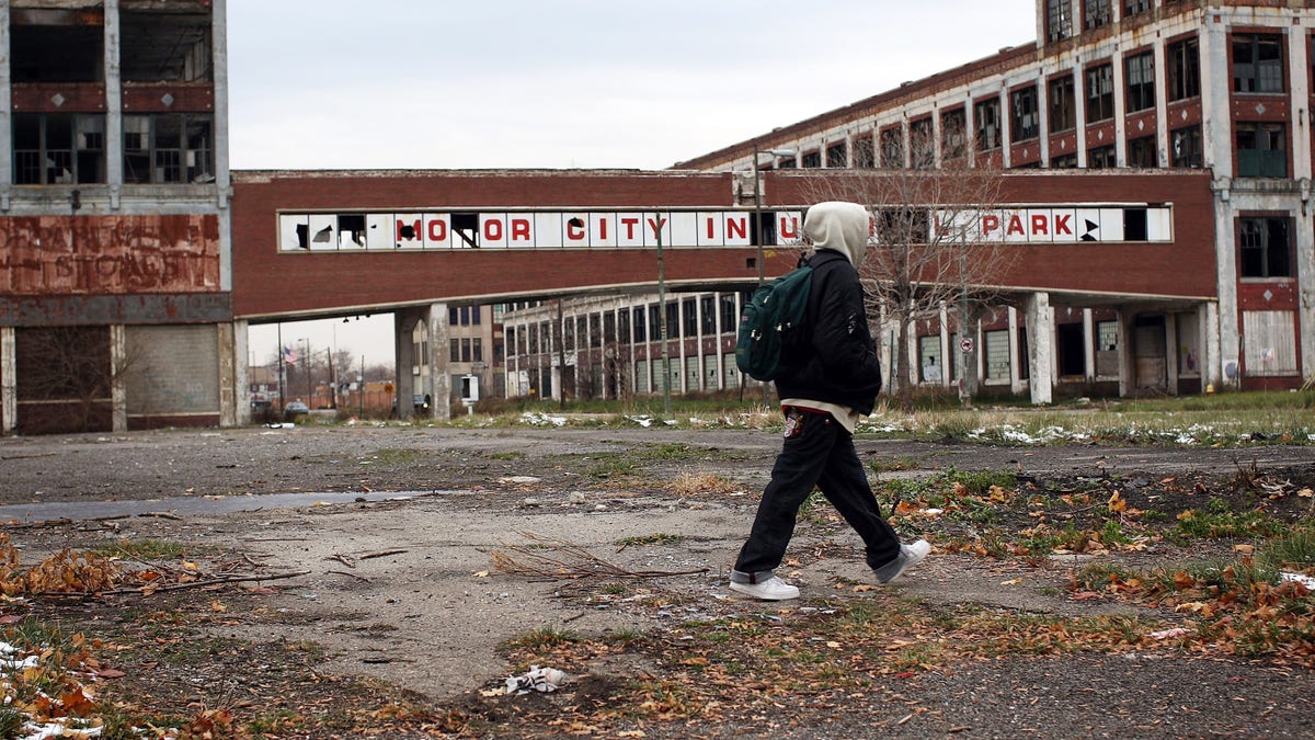 A person walks past the remains of the Packard Motor Car Company, which ceased production in the late 1950s, on Nov. 19, 2008 in Detroit, Michigan. 