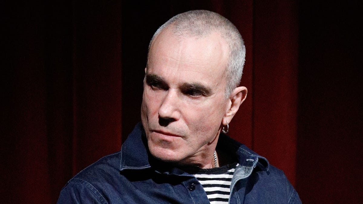 Daniel Day-Lewis with shaved head holding a microphone
