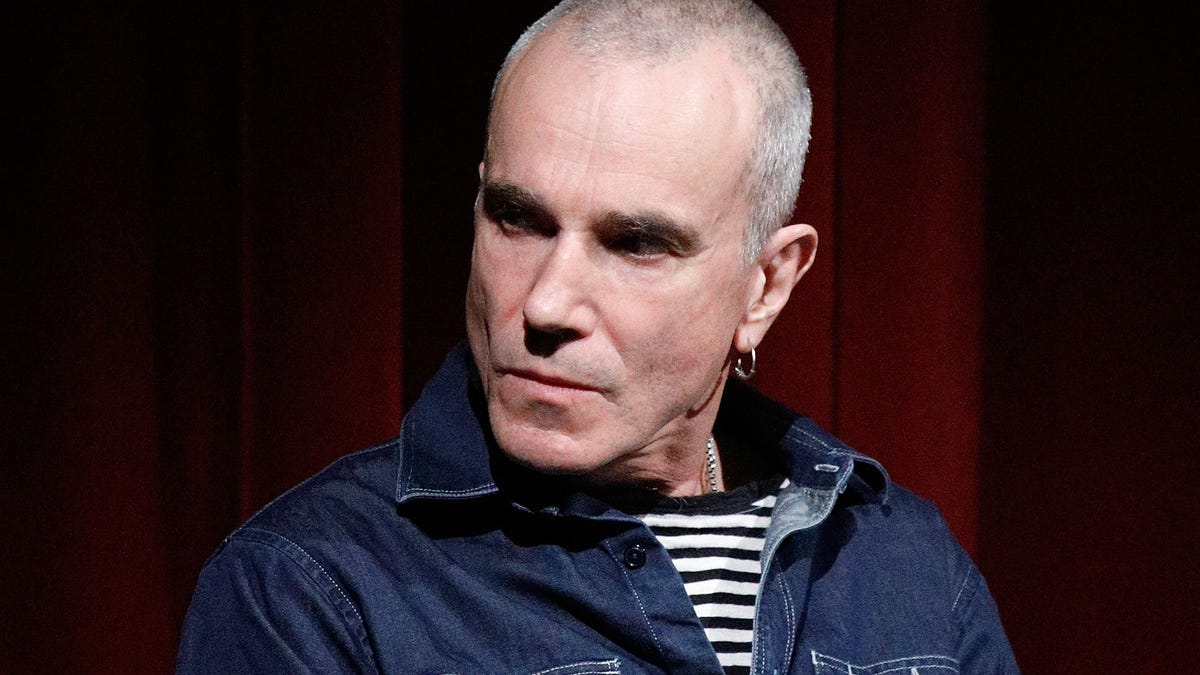 Daniel Day-Lewis with shaved head holding a microphone