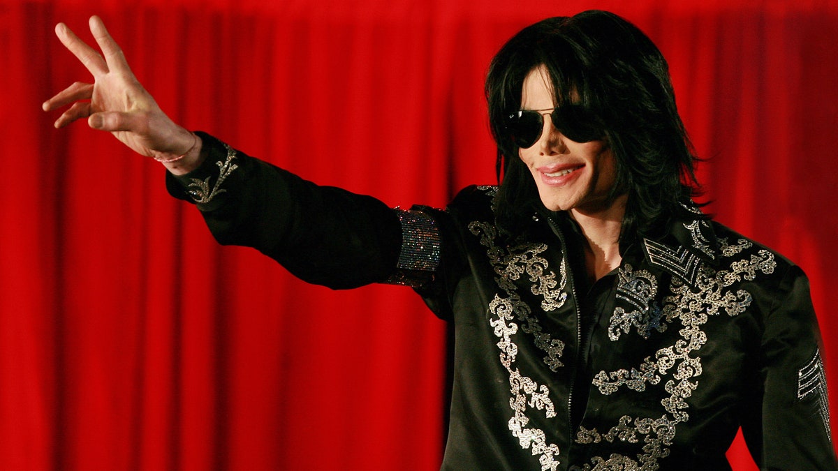 Michael Jackson wearing sunglasses and giving peace sign