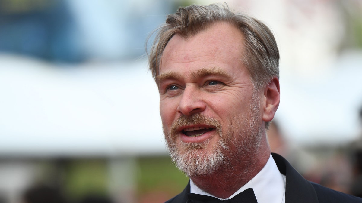 Christopher Nolan looks off in the distance at Cannes Film Festival in a tuxedo