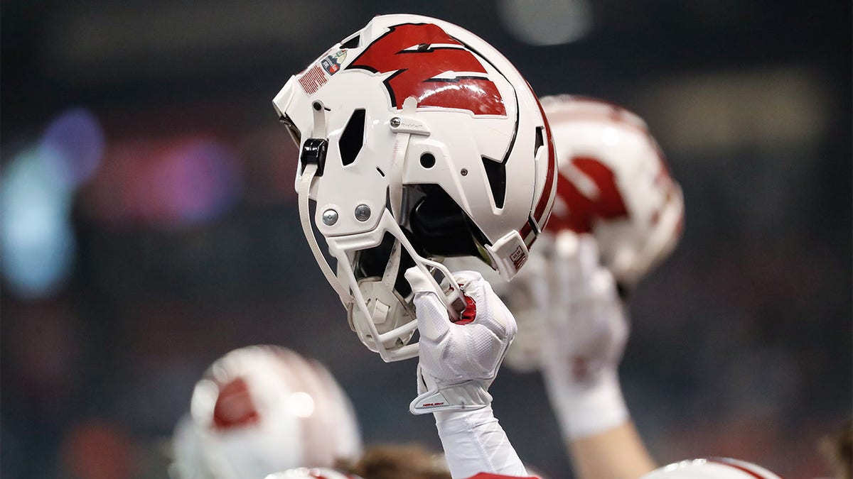 A player holds up his Wisconsin helmet