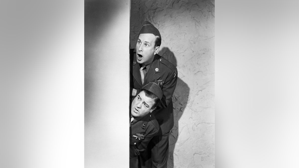 Bud Abbott and Lou Costello wearing military uniforms while looking surprised in a comedy skit