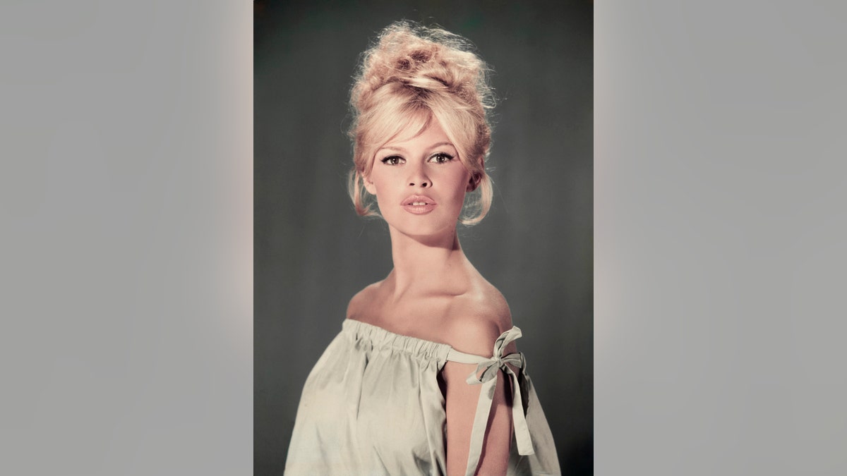 A portrait of Brigitte Bardot wearing a light hue dress in 1960