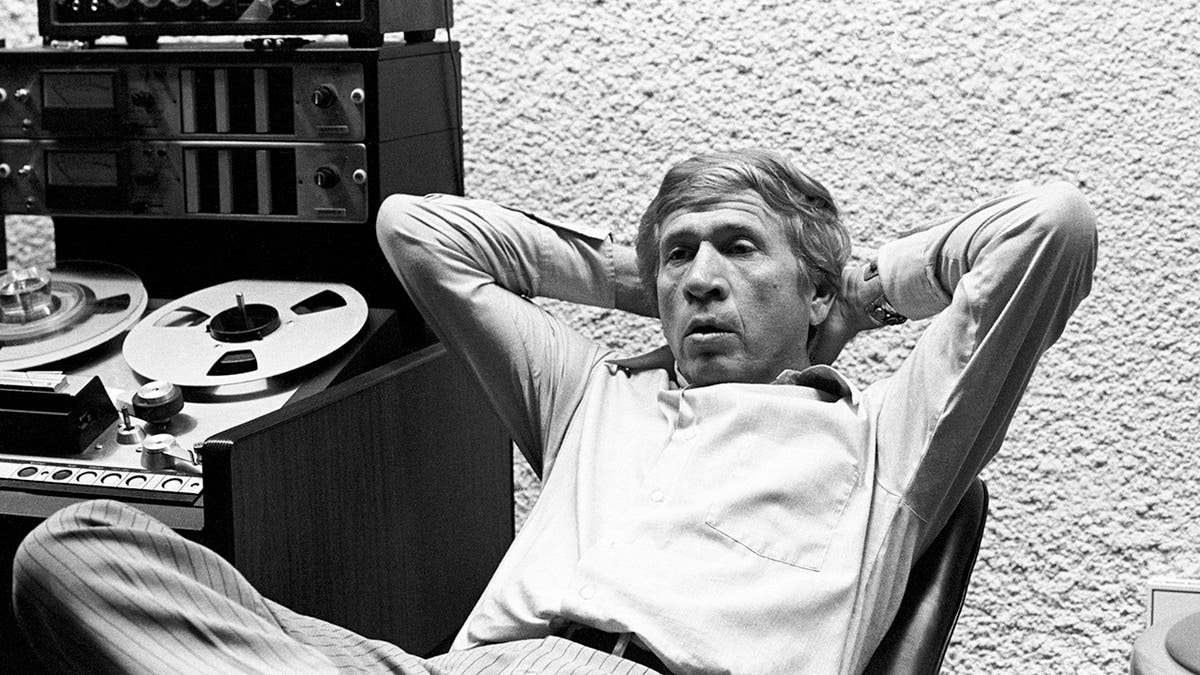 Buck Owens leaning back on a chair in his recording studio