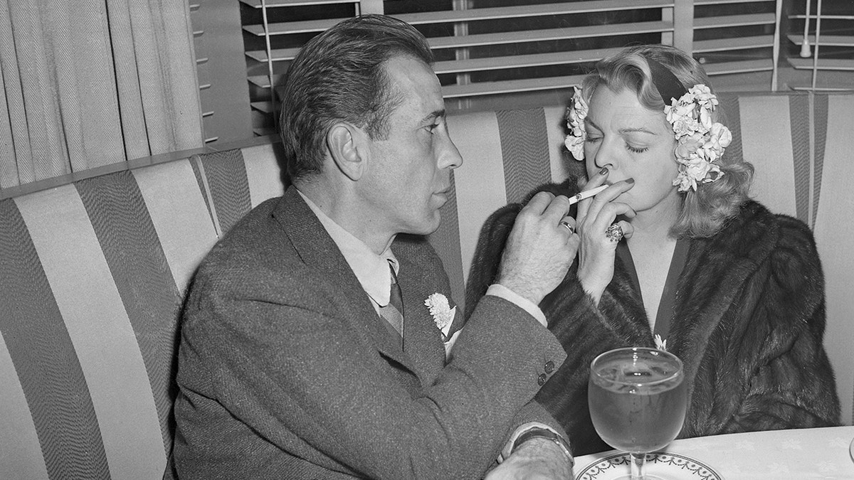 Humphrey Bogart holding Mayo Methots cigarette