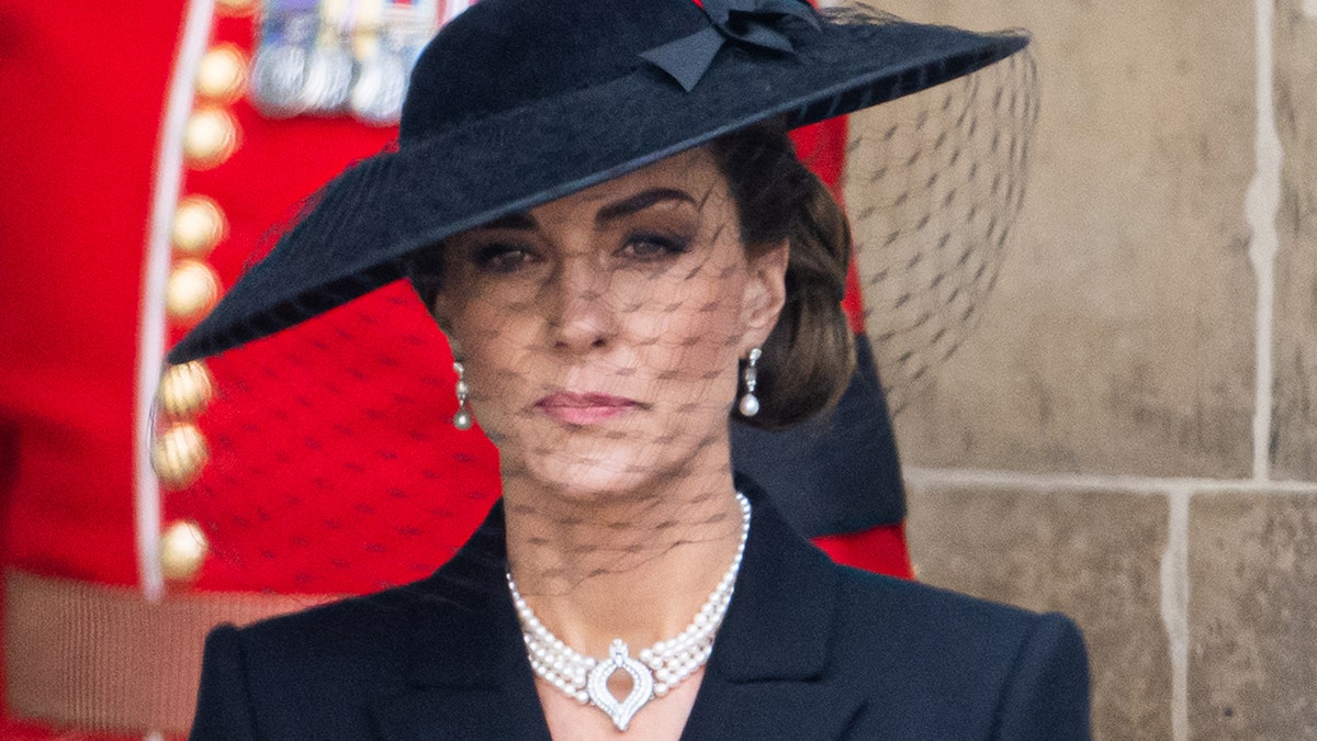 a close-up of Kate Middleton wearing a black dress at a funeral
