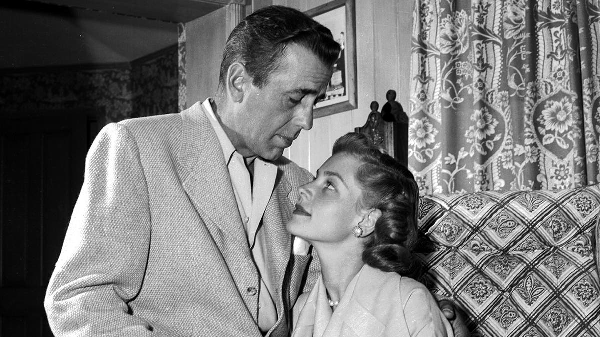 Lauren Bacall looking up at her husband Humphrey Bogart in their home