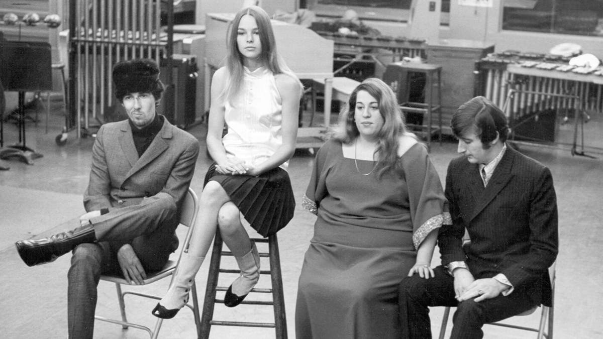 The Mamas and the Papas sitting together looking serious