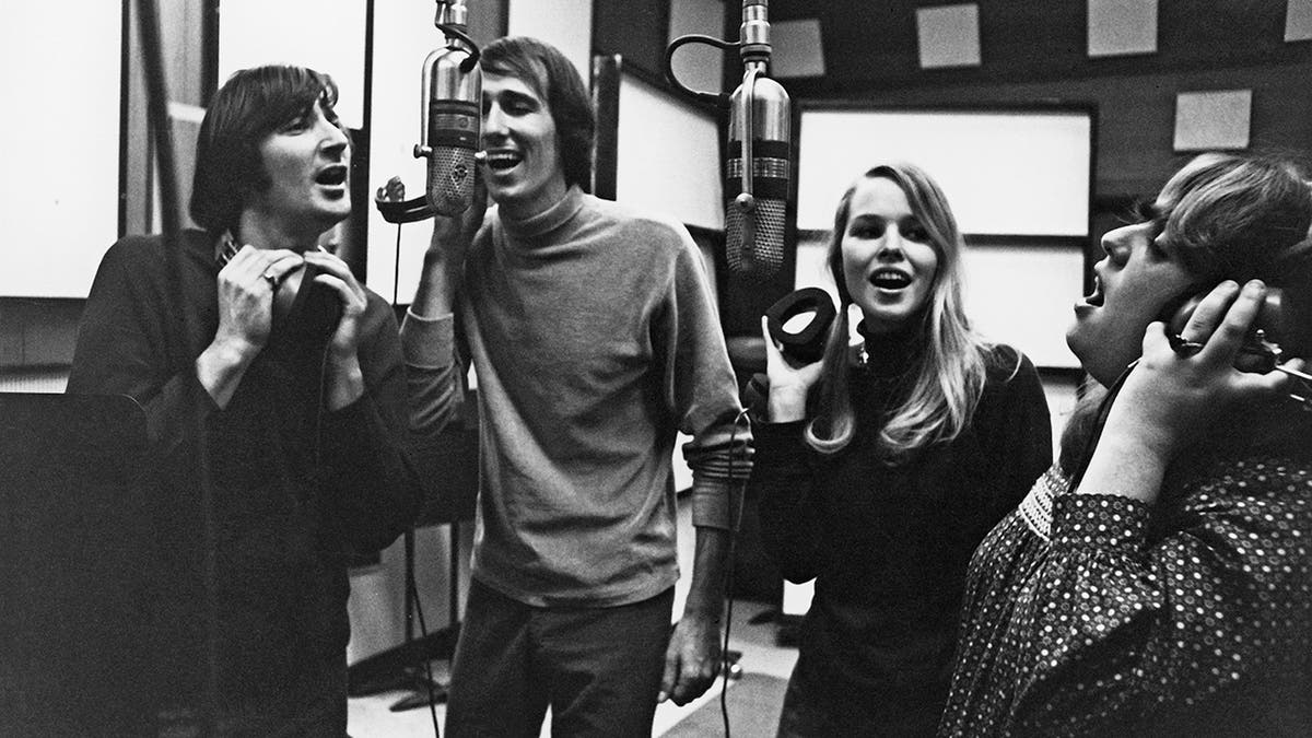 The Mamas and The Papas singing together in a recording studio