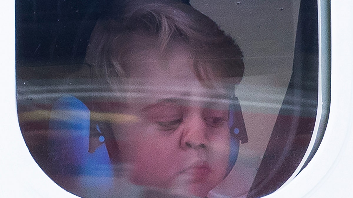 Prince George making a funny face while wearing headphones
