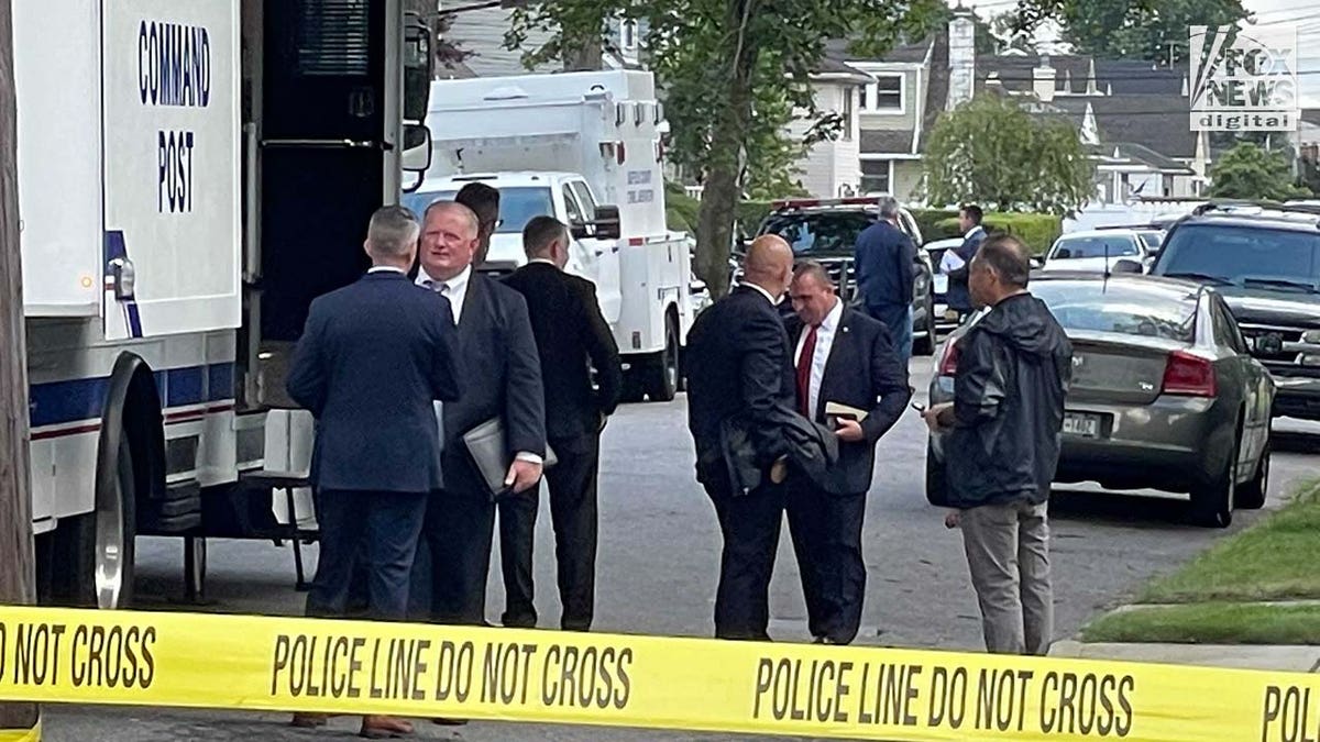 Suffolk County police outside command post behind police tape
