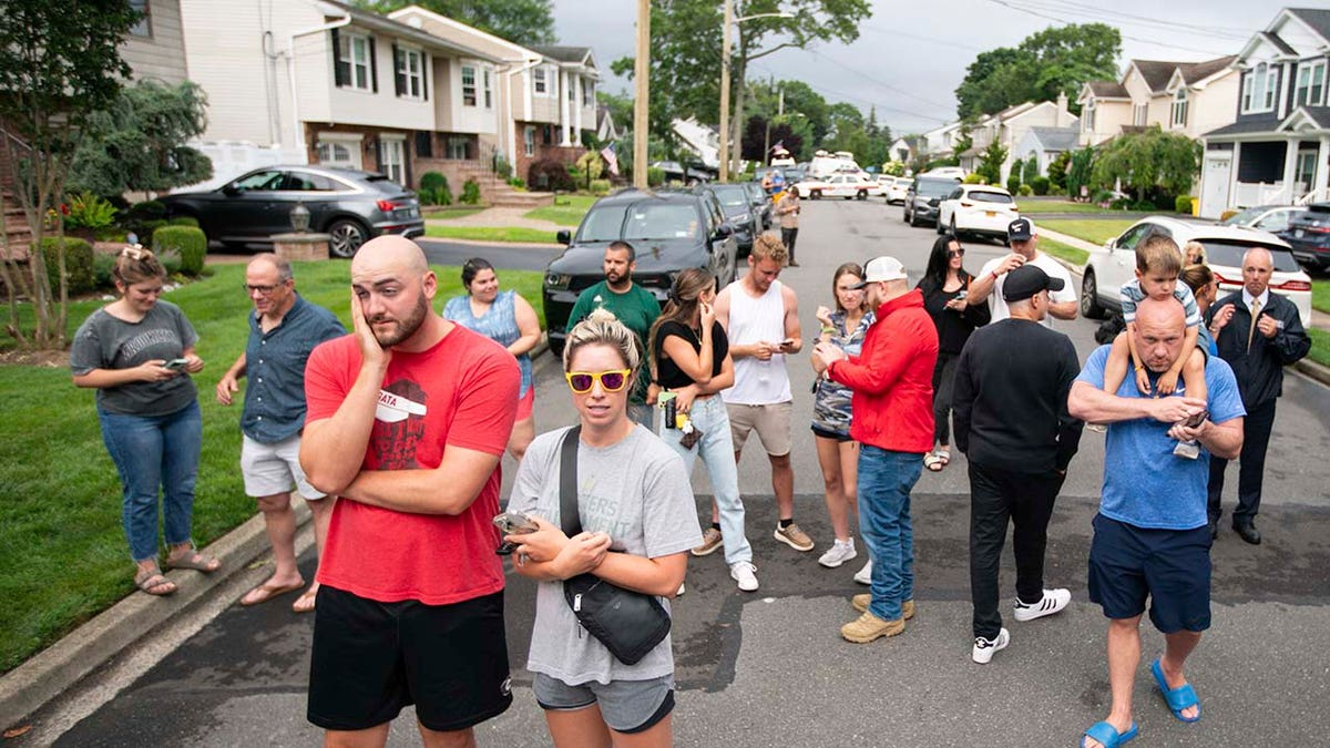 Residents stand outside of the home of Rex Heuermann