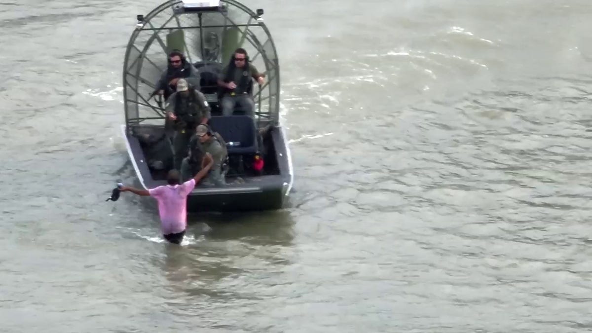 suspect being taken into custody in river